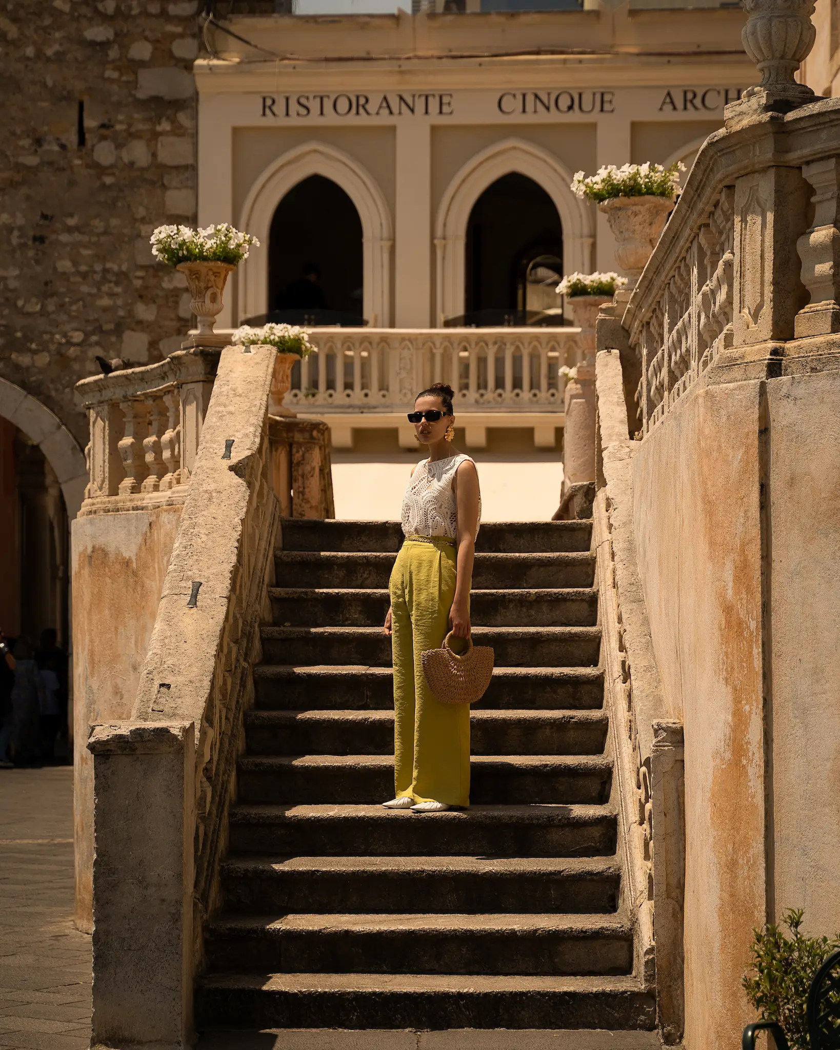 A woman standing in Taormina's church stairs